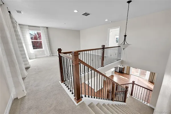 a view of a hallway with stairs and furniture