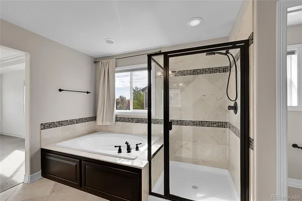 a bathroom with a tub sink shower and mirror