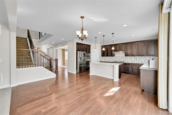 a large white kitchen with a stove a sink dishwasher a kitchen with cabinets and wooden floor