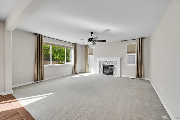 a view of an empty room with window and fire place