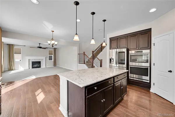 a kitchen with kitchen island a sink stainless steel appliances and a chandelier