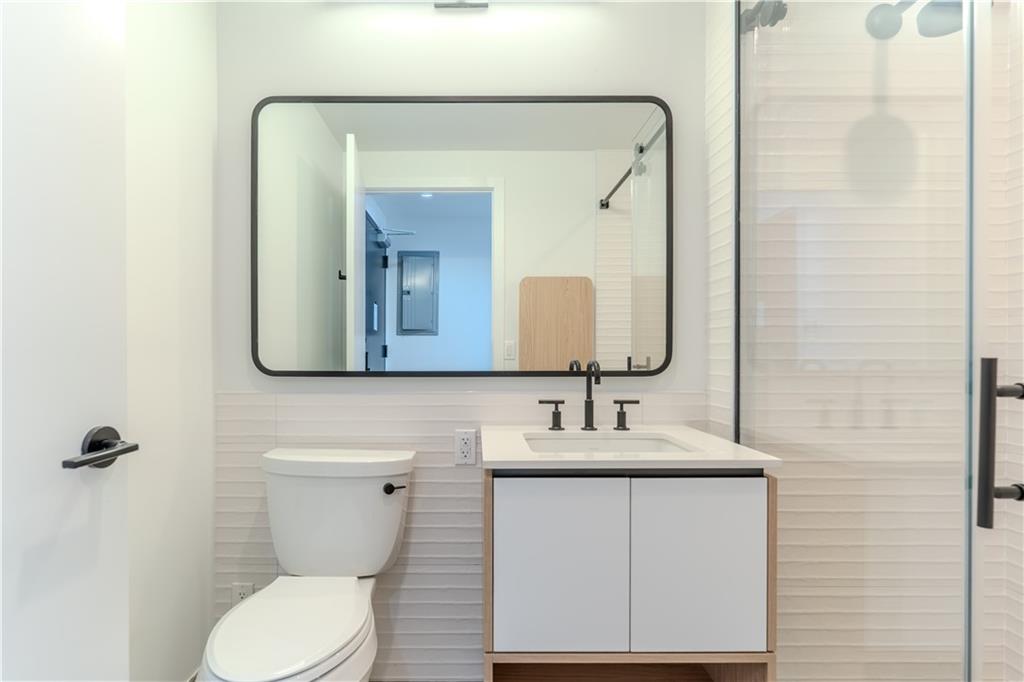1807 66th Street, Unit 3D Brooklyn, NY 11204 - Photo 6 of 7 a bathroom with a toilet sink and mirror
