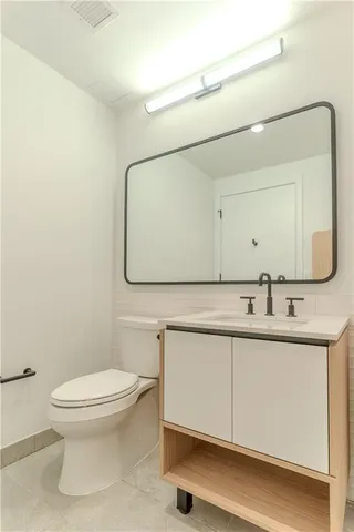 a bathroom with a toilet sink and mirror
