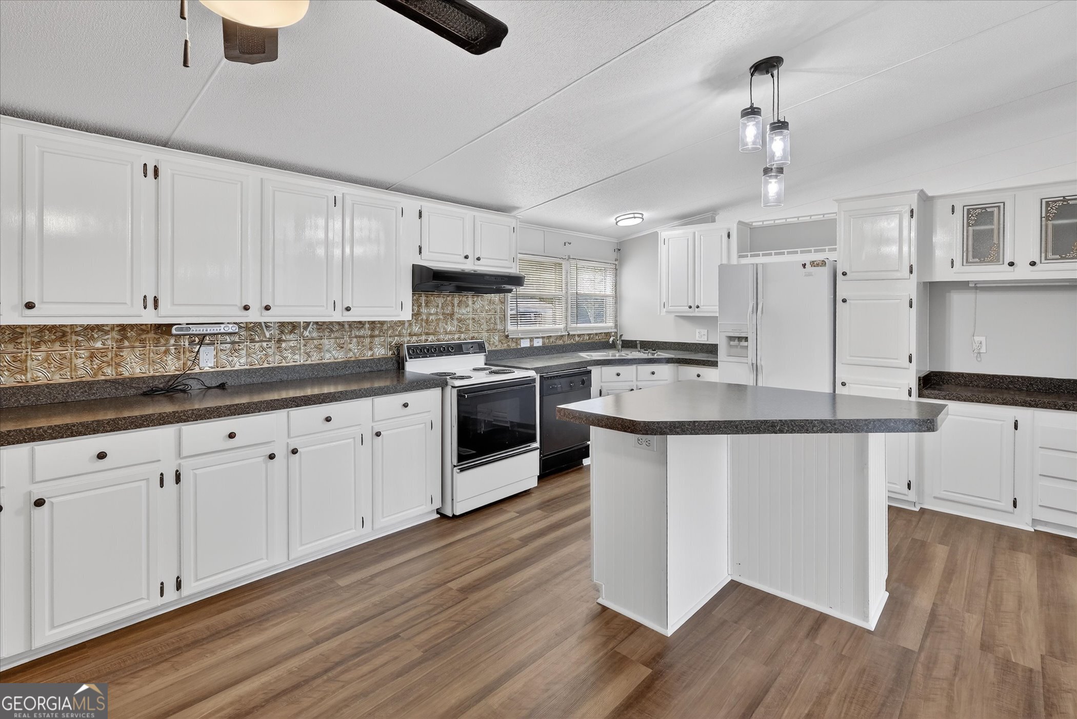 13541 Pine Burr Road Metter, GA 30439 - Photo 12 of 44 a kitchen with kitchen island granite countertop a sink a counter space stainless steel appliances and cabinets
