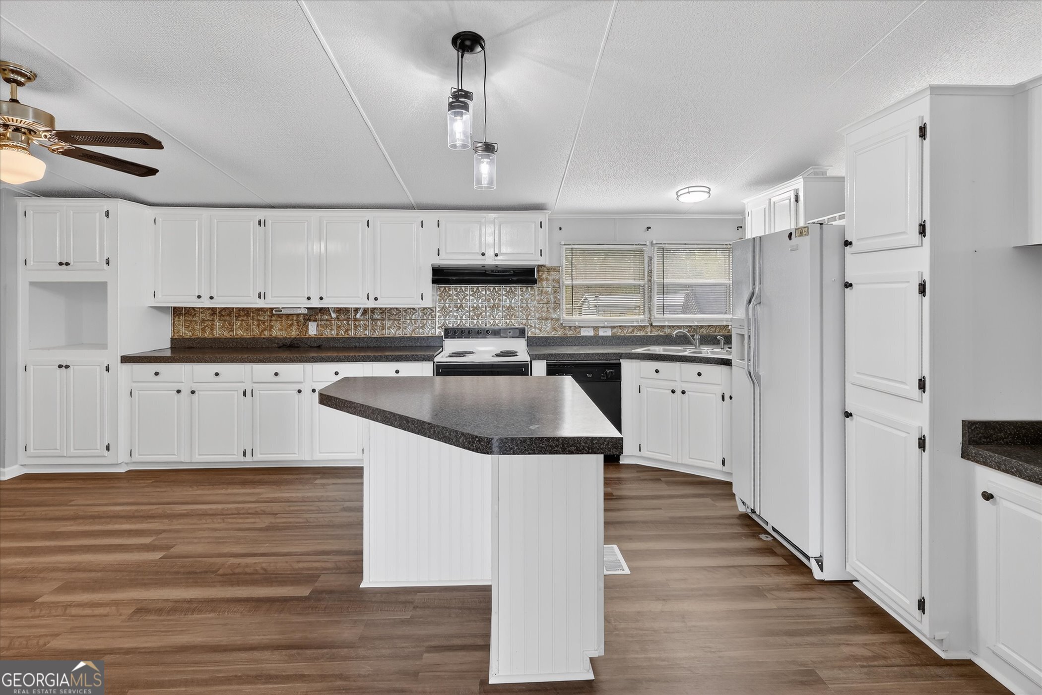 13541 Pine Burr Road Metter, GA 30439 - Photo 14 of 44 a kitchen with stainless steel appliances granite countertop a stove a sink and a refrigerator