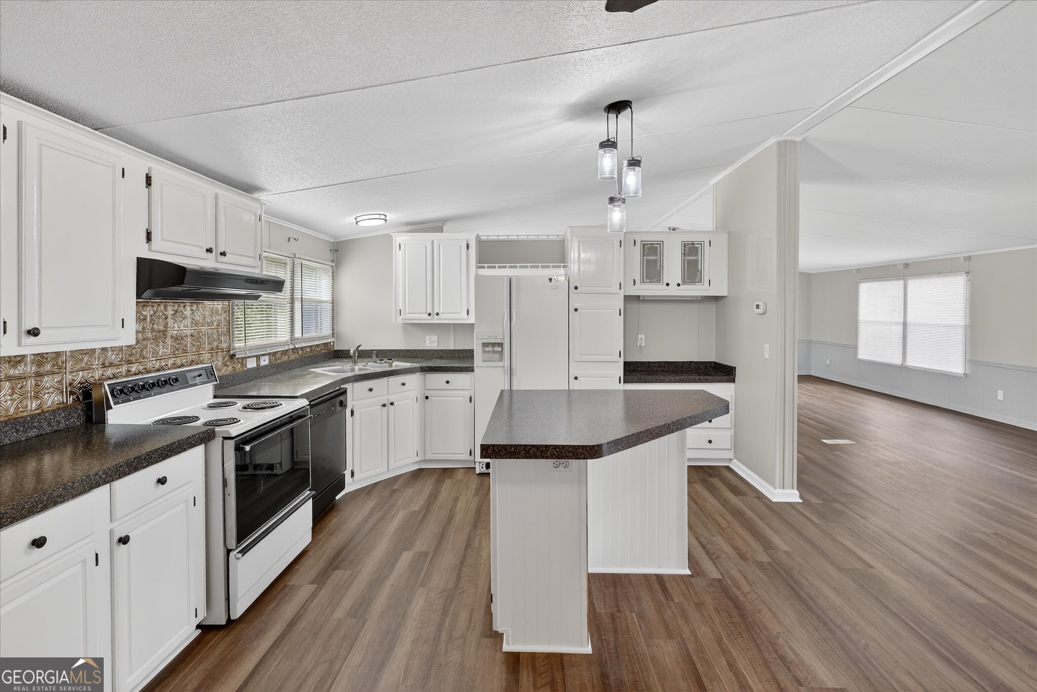 13541 Pine Burr Road Metter, GA 30439 - Photo 17 of 44 a kitchen with granite countertop a sink cabinets and wooden floor