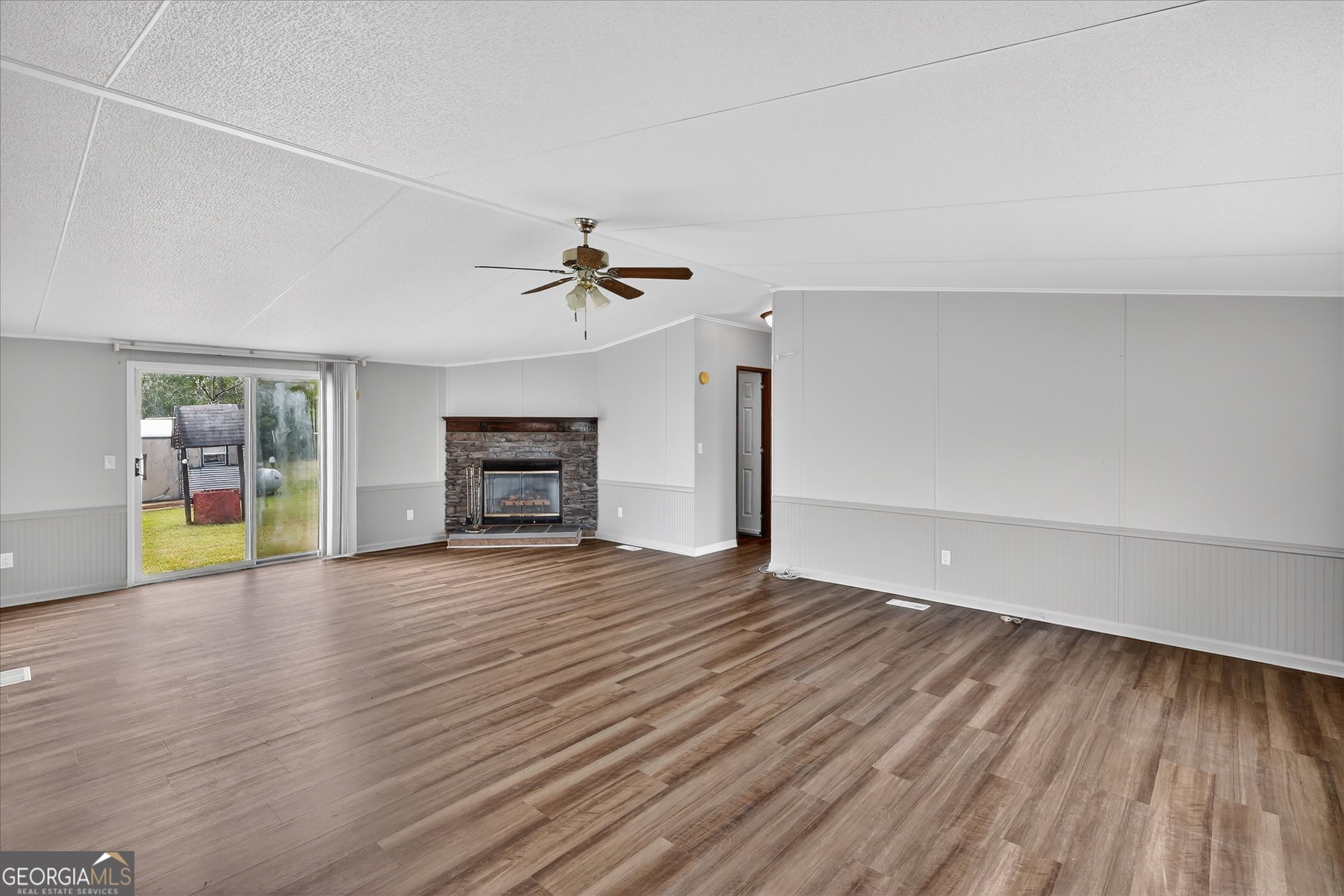 13541 Pine Burr Road Metter, GA 30439 - Photo 5 of 44 a view of an empty room with wooden floor fireplace and a window