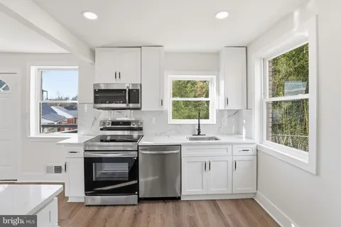 a kitchen with a stove a sink and a window