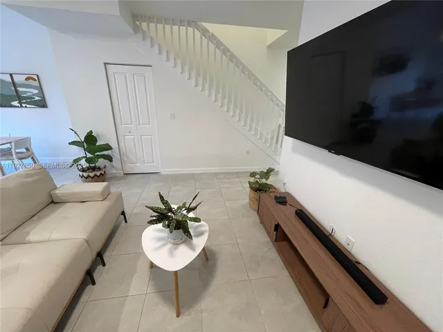 a hallway with a couches and a potted plant on a dresser