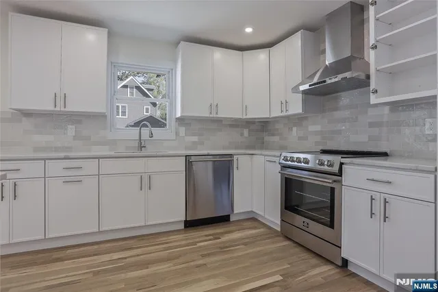 a kitchen with stainless steel appliances granite countertop a sink stove and cabinets