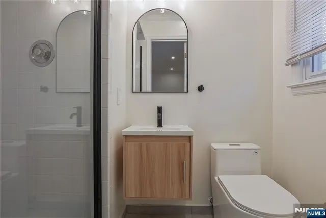 a bathroom with a toilet a sink a vanity and mirror