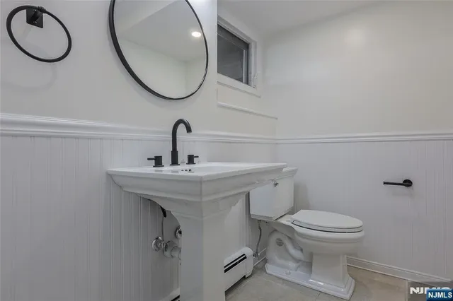 a bathroom with a toilet a sink and a mirror