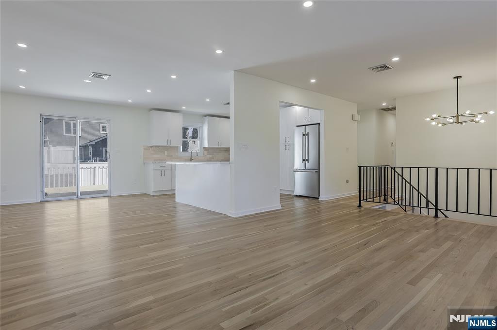 18 Ruth Lane Demarest, NJ 07627 - Photo 6 of 35 a view of empty room with wooden floor and kitchen