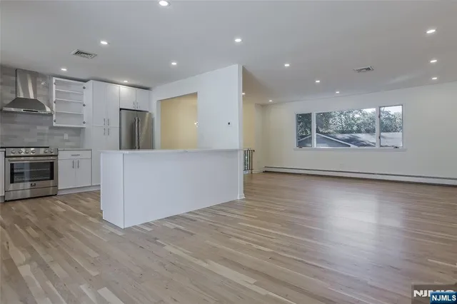 an empty room with wooden floor and natural light