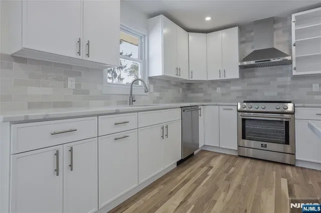 a kitchen with white cabinets stainless steel appliances and sink
