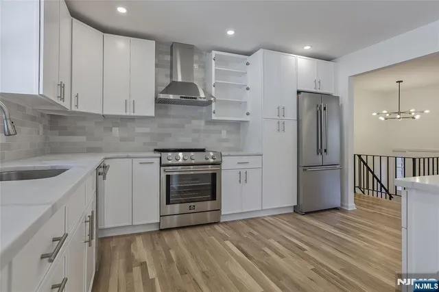 a kitchen with stainless steel appliances granite countertop a refrigerator a sink and a stove