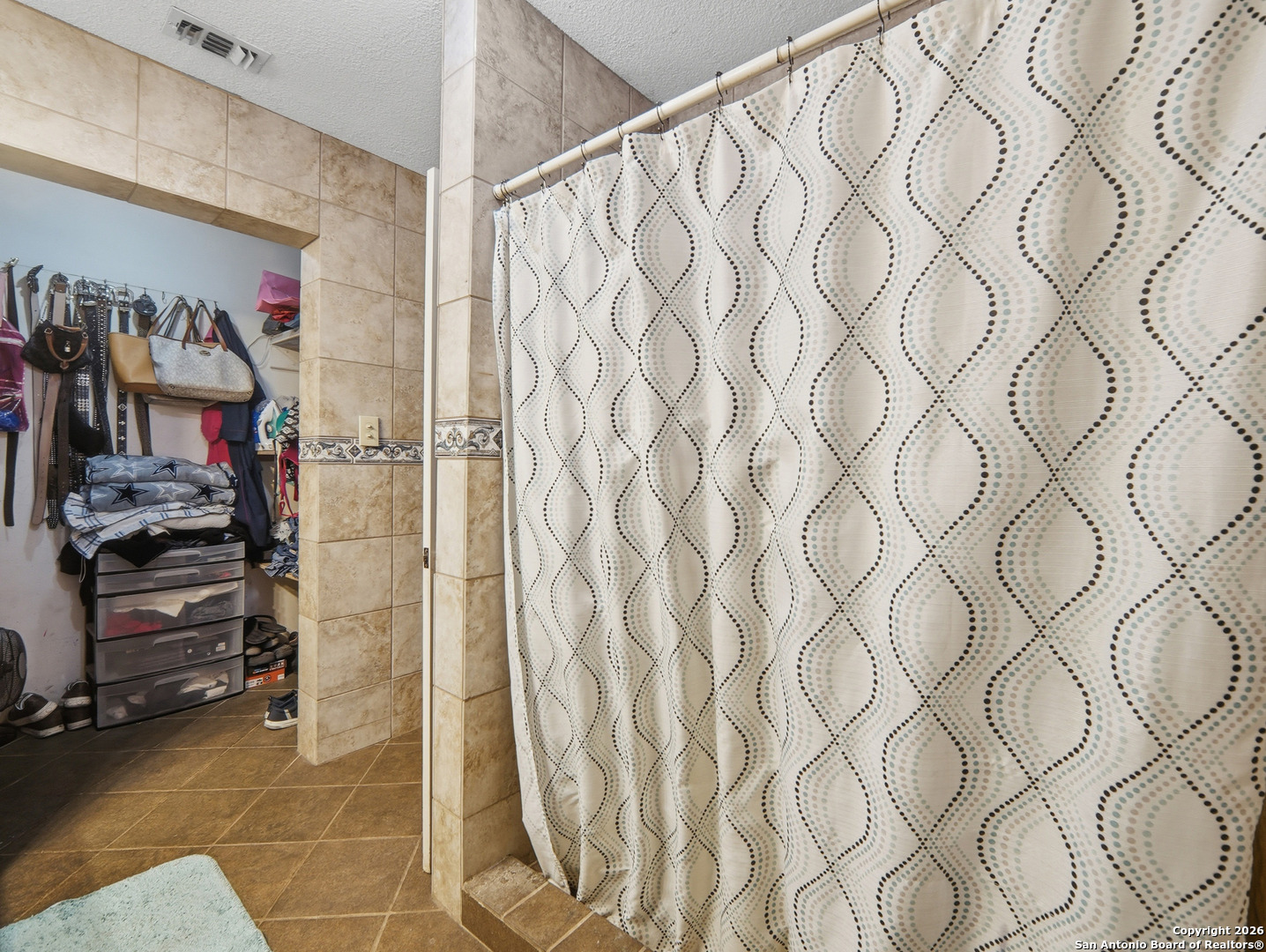 17525 Benton City Road Von Ormy, TX 78073 - Photo 19 of 36 a view of walk in closet with clothes