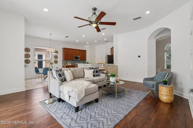 a living room with furniture a dining table and a potted plant