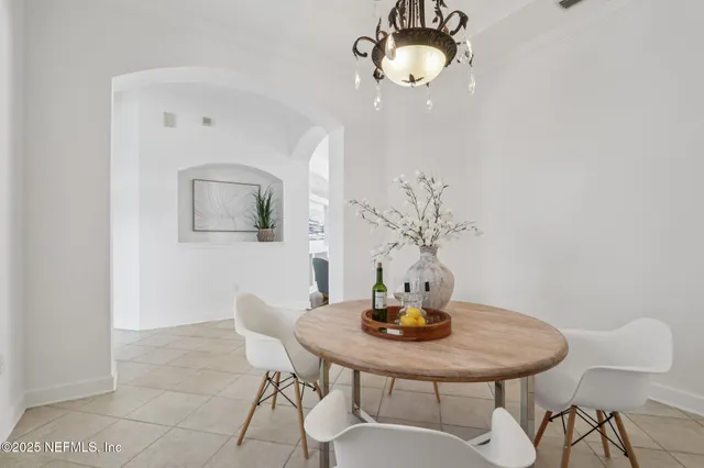 a dining room with furniture a chandelier and window