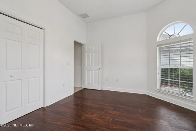 a view of an empty room with wooden floor