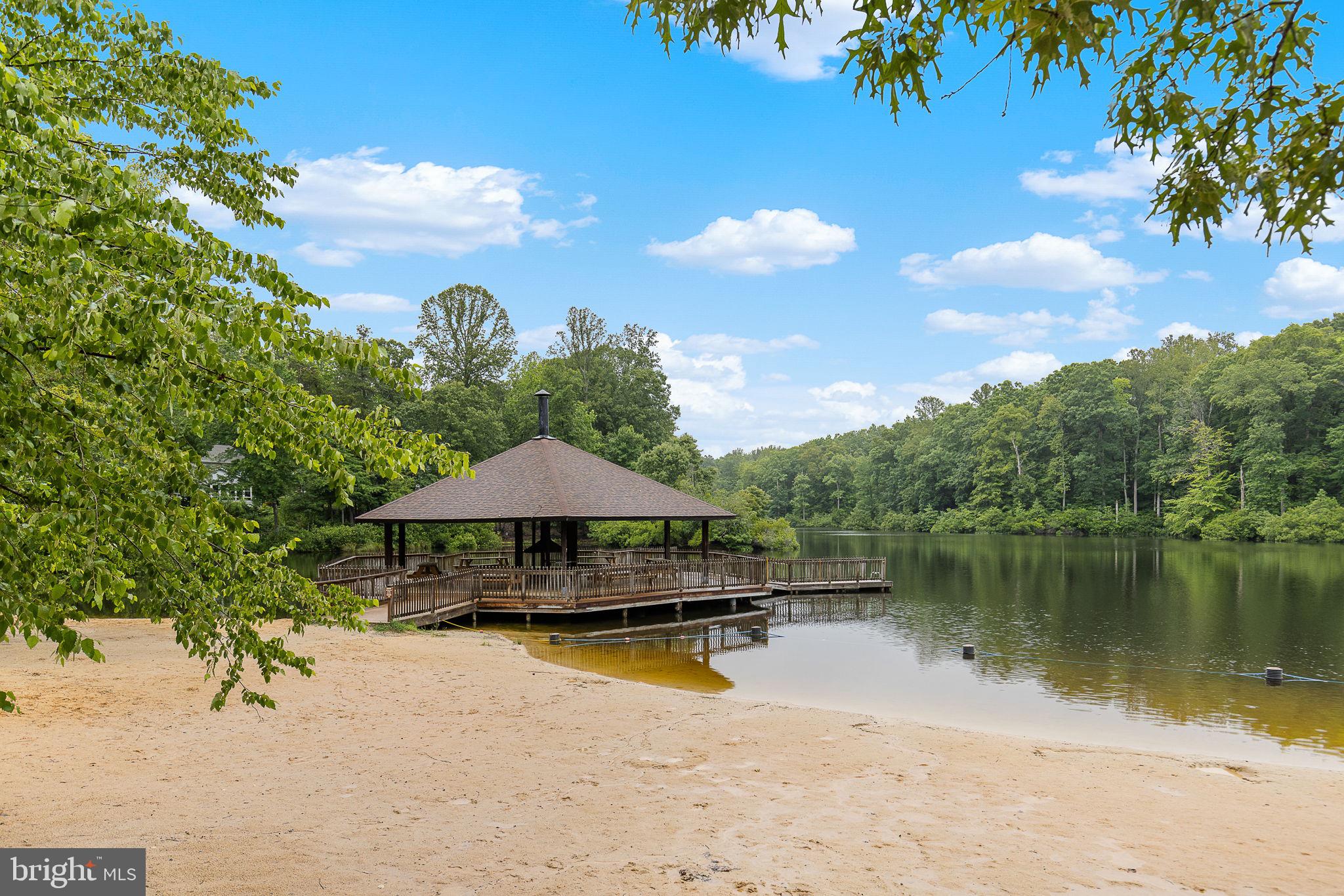 6199 Curtis Circle King George, VA 22485 - Photo 28 of 33 a backyard of a house with table and chairs under an umbrella