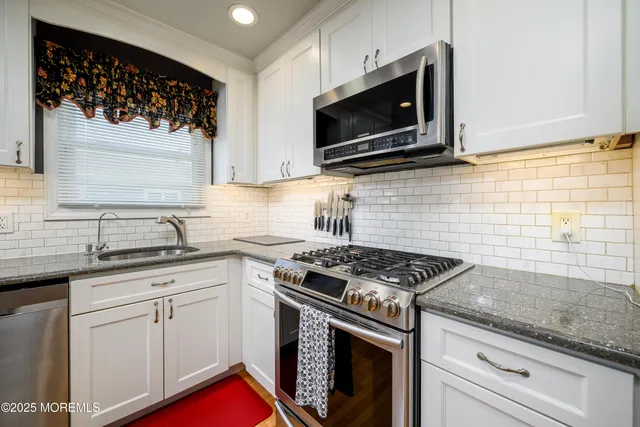 a kitchen with stainless steel appliances granite countertop a sink stove top oven and microwave