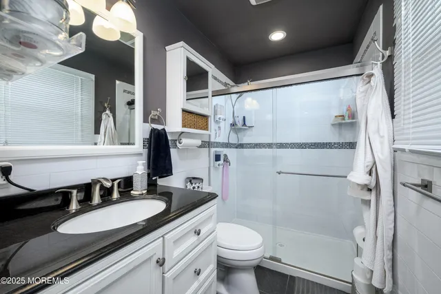 a bathroom with a sink a toilet and a mirror