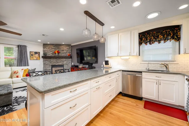 a kitchen with granite countertop a stove and white cabinets