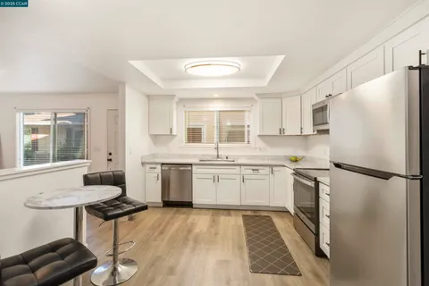 a kitchen with stainless steel appliances granite countertop a stove a refrigerator and a sink