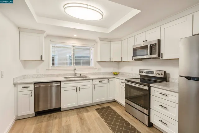 a kitchen with stainless steel appliances granite countertop a stove a sink and a microwave