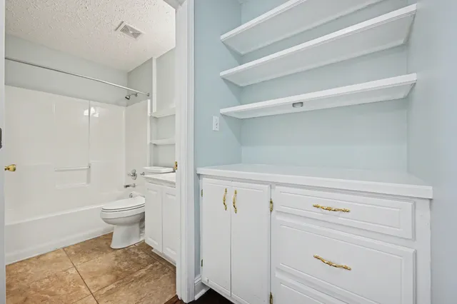 a bathroom with a white toilet and a shower