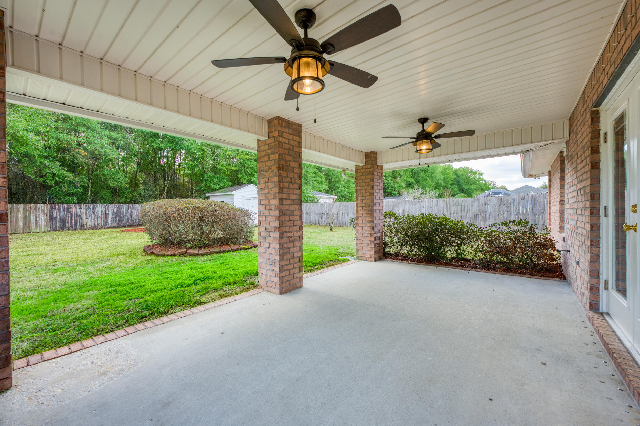 5127 Brookside Drive Pace, FL 32571 - Photo 21 of 25 a view of a backyard with plants and a garden
