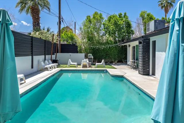 a view of house with swimming pool outdoor seating
