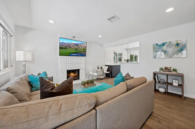 a living room with furniture a fireplace and wooden floor
