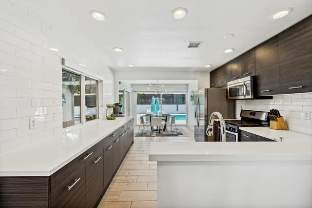a large kitchen with kitchen island a large window a sink and counter space