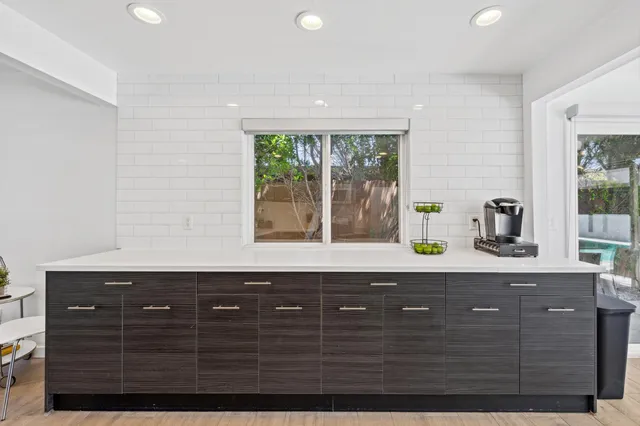 a sink sitting in a spacious bathroom with a granite countertop sink