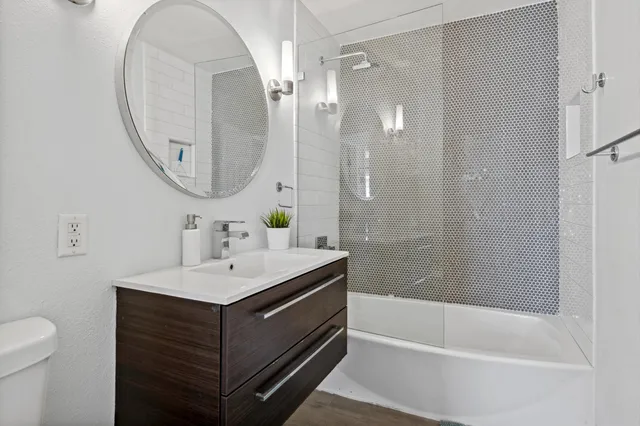 a bathroom with a sink a toilet and a mirror