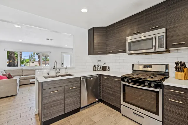 a kitchen with stainless steel appliances a stove sink and cabinets