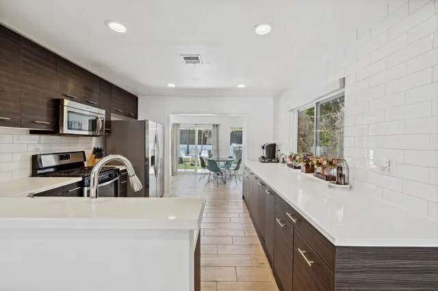 a large white kitchen with a large window