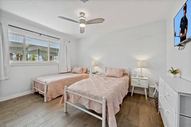 a bedroom with two beds and a chandelier
