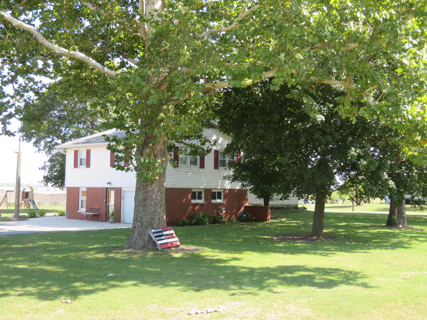 7740 Lisbon Road Morris, IL 60450 - Photo 2 of 2 a front view of a house with a garden and trees