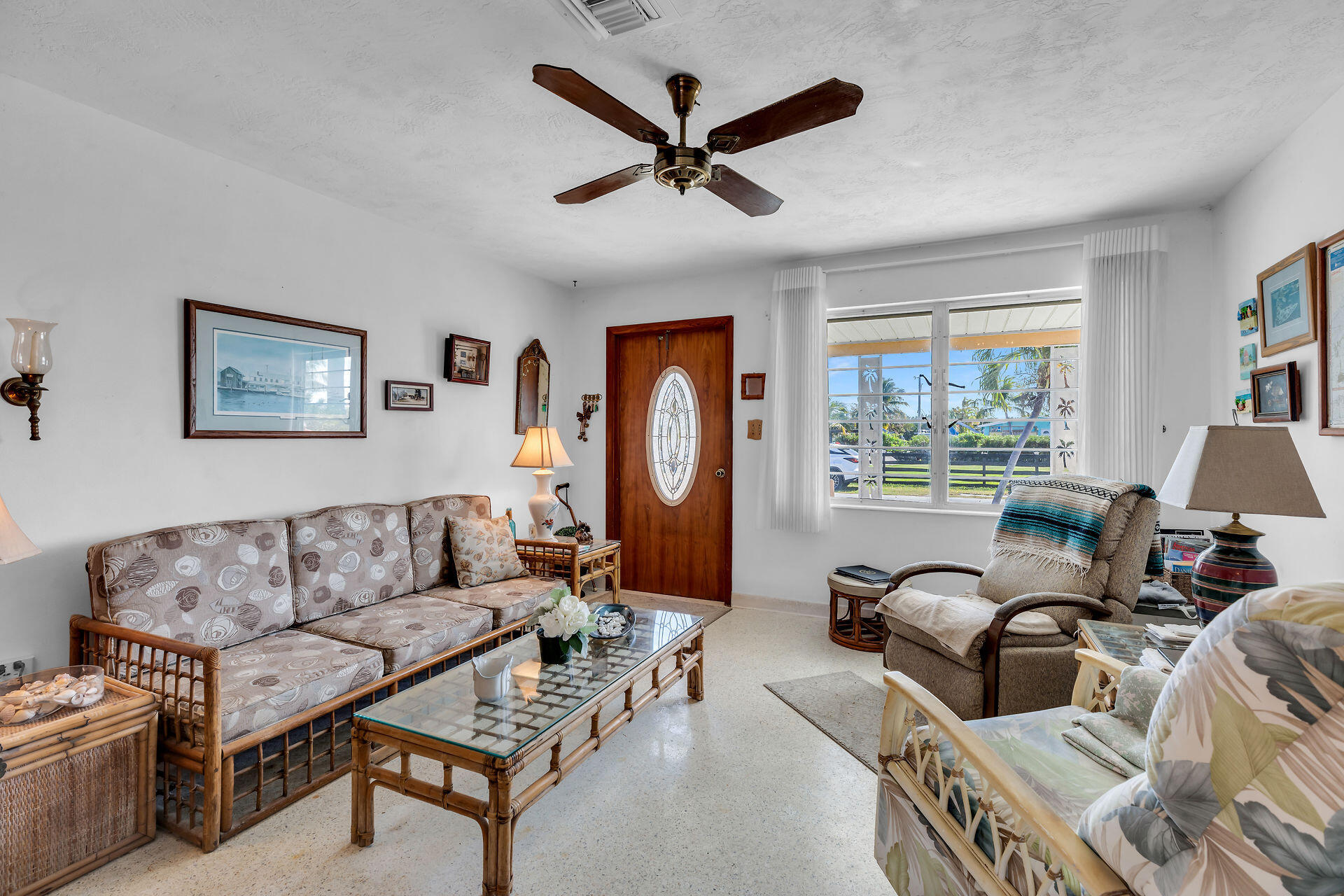 30361 Harding Road Big Pine Key, FL 33043 - Photo 19 of 33 a living room with furniture a ceiling fan a fireplace and a large window