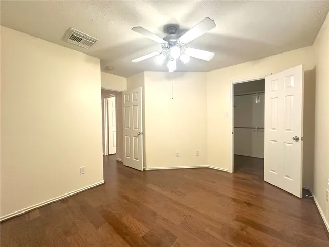 an empty room with a window and a ceiling fan