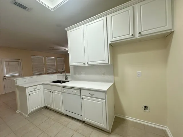 a kitchen with white cabinets and white appliances