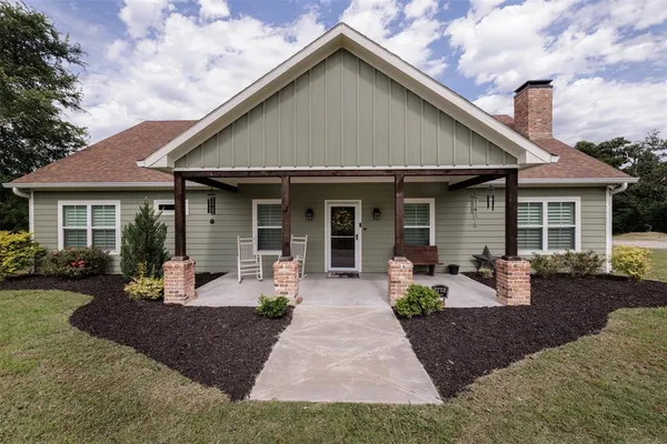 a front view of a house with sitting area and garden