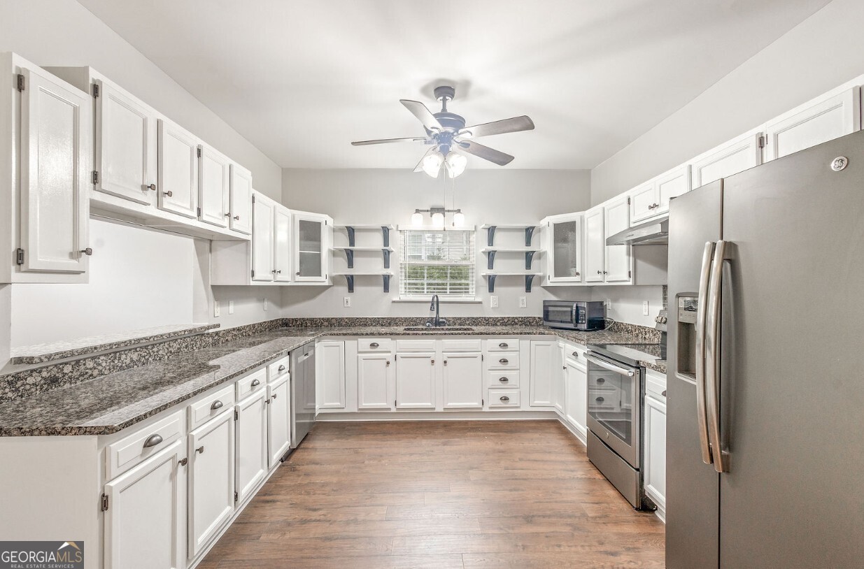 82 Newton Road LaGrange, GA 30240 - Photo 10 of 45 a kitchen with granite countertop a white cabinets stove and refrigerator