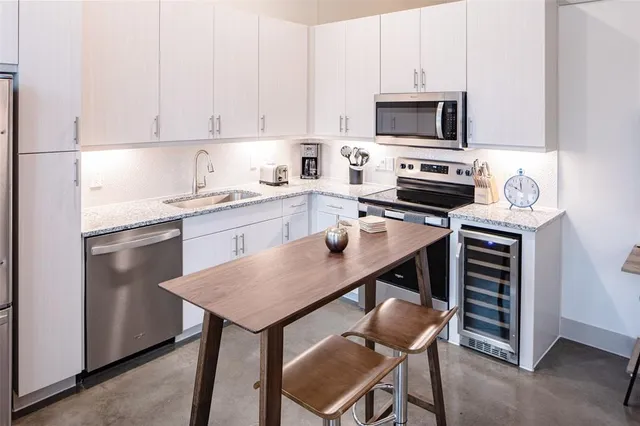 a kitchen with stainless steel appliances a stove a sink and a refrigerator