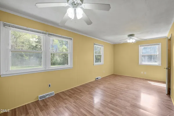 a view of a big room with wooden floor and a ceiling fan