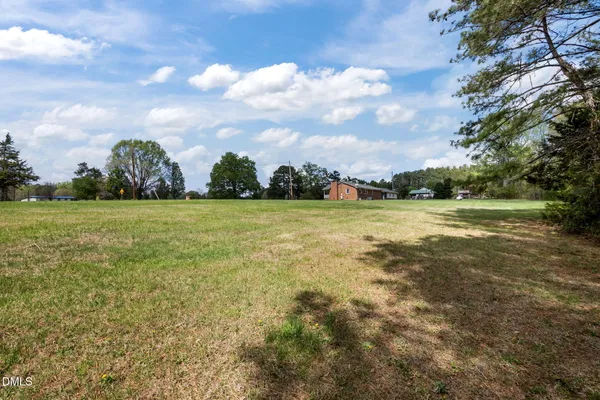 a view of a green field with wooden fence