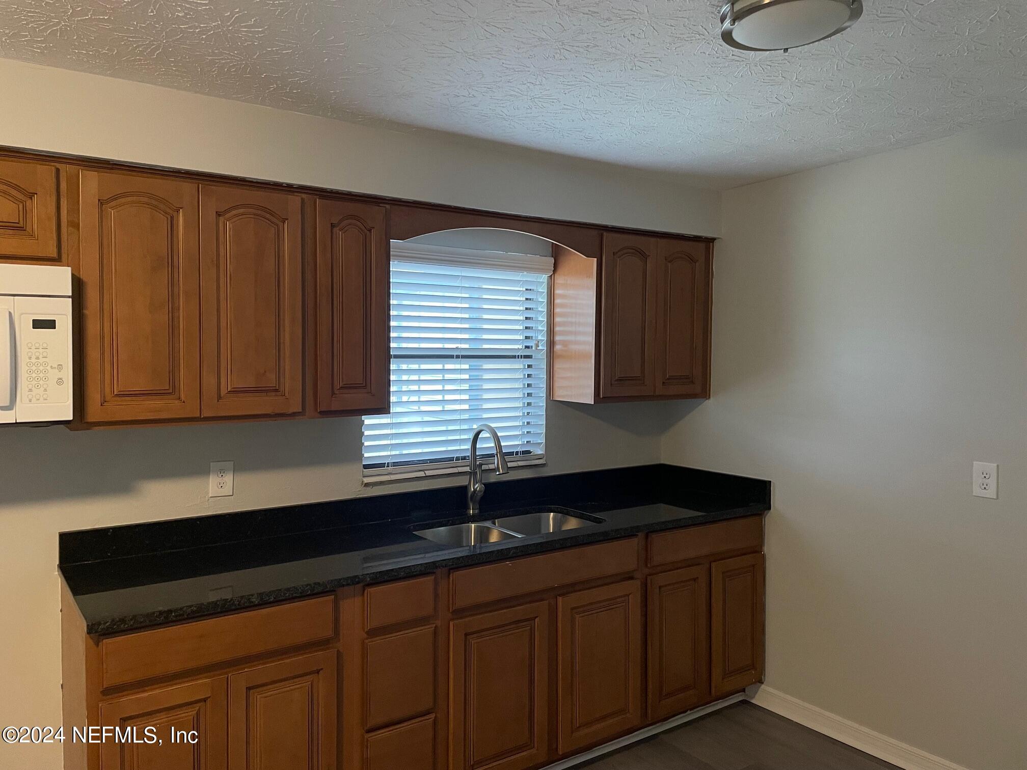440 Sargo Road Atlantic Beach, FL 32233 - Photo 2 of 15 a kitchen with granite countertop cabinets sink and window